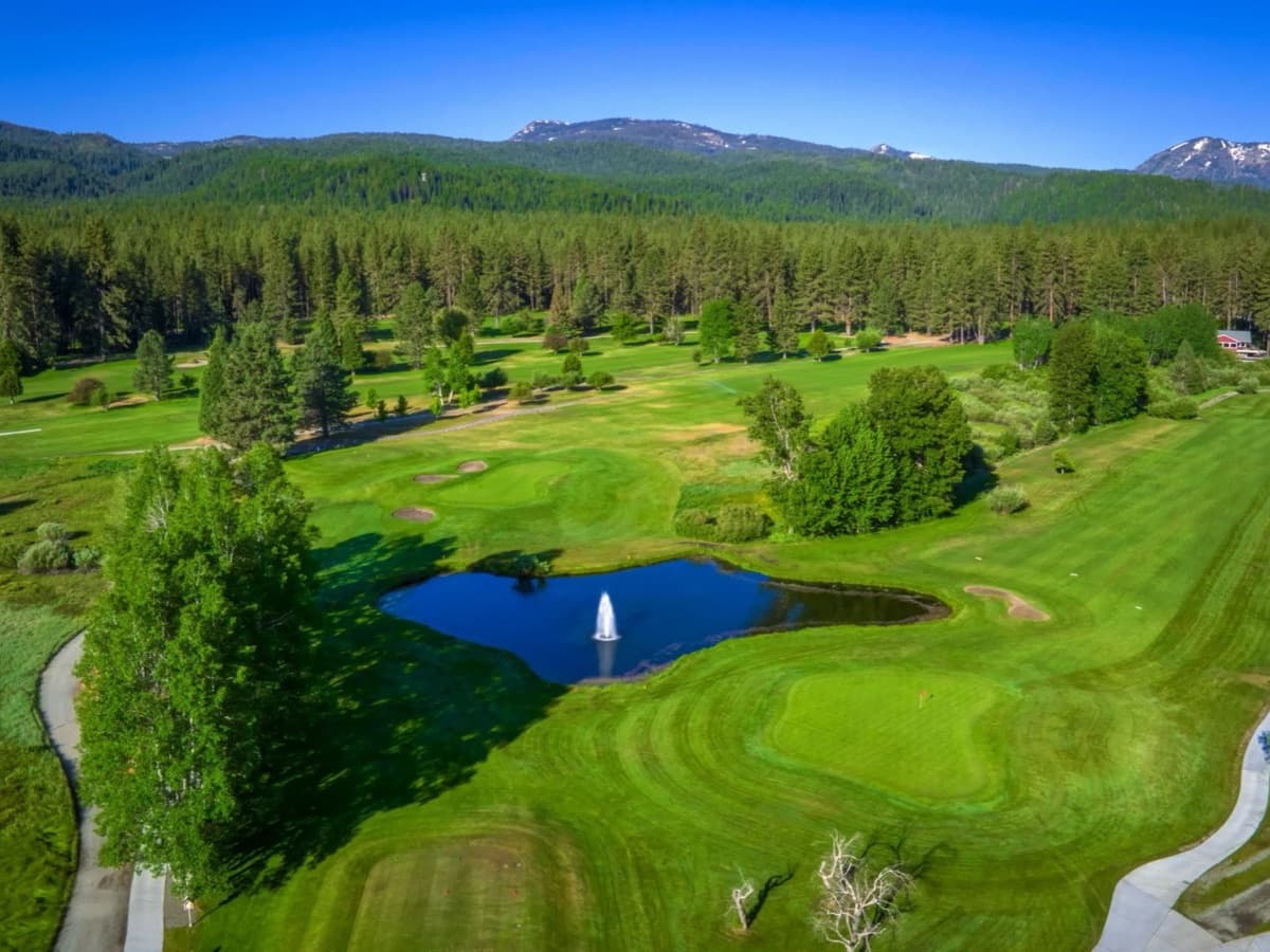 Aerial view of Graeagle Meadows Golf Course showing the fairways, water feature, and Sierra ridgeline