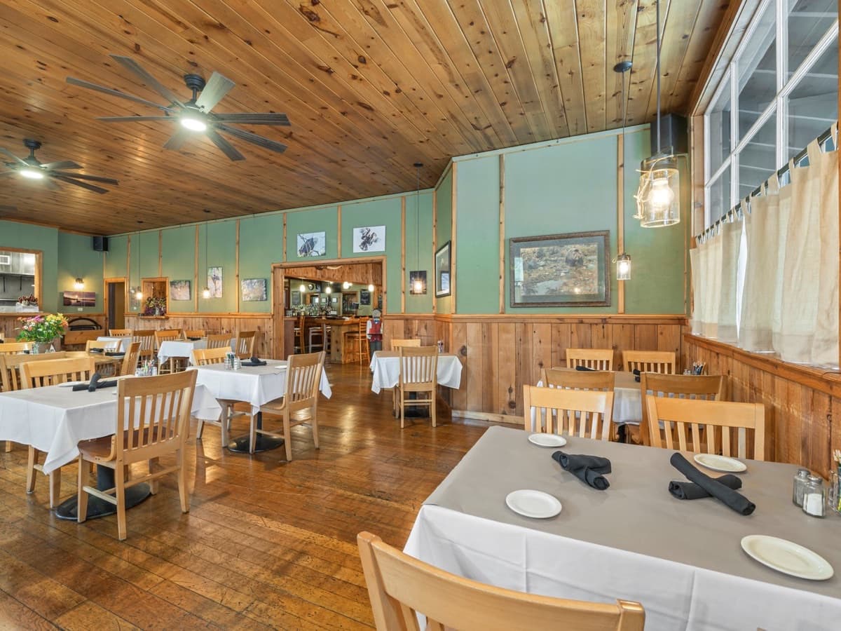 The Grizzly Grill dining room in Blairsden with knotty-pine walls and white-linen tables