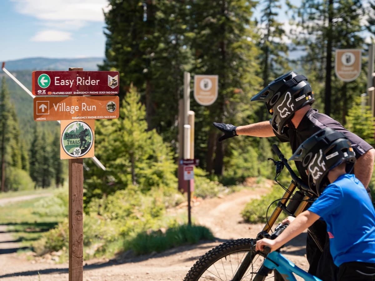 Mountain bikers reading trail signs on the Northstar trail network that Tompkins Trail connects into